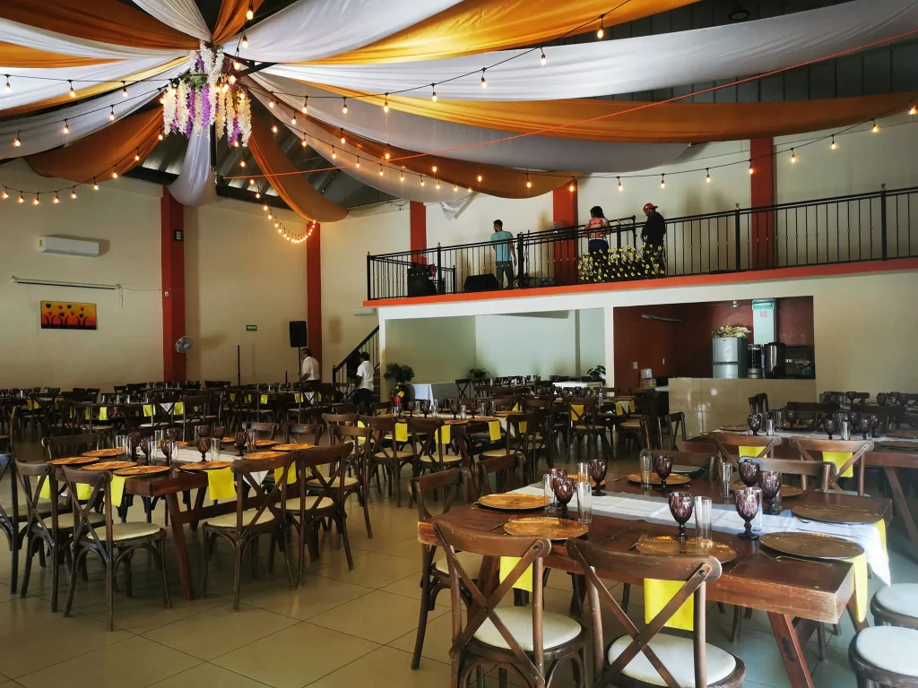 Salón de eventos con mesas decoradas con estilo rústico y elegante