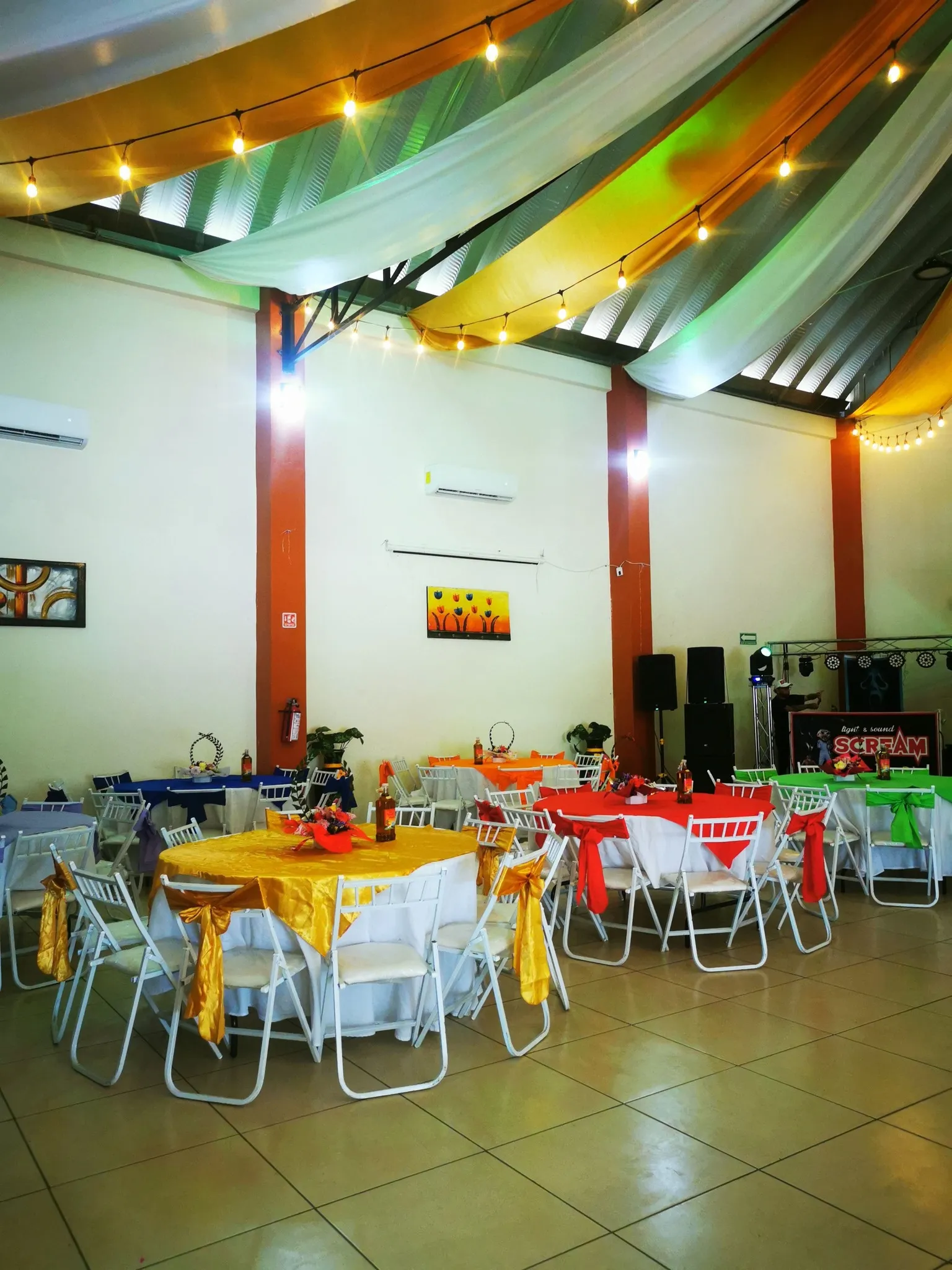 Un salón decorado con telas y luces para un evento especial