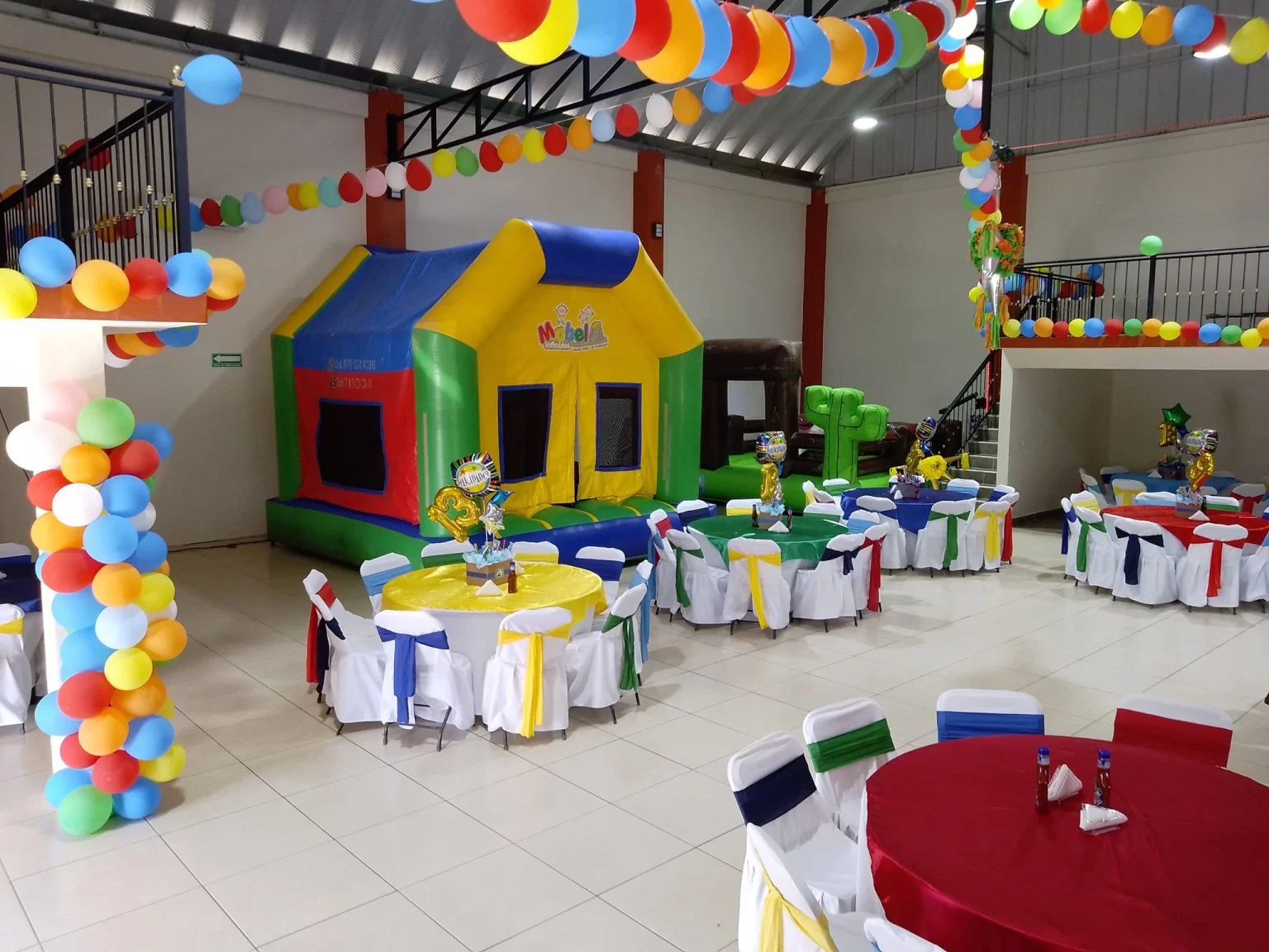 Fiesta infantil con juegos inflables y mesas decoradas con colores vivos