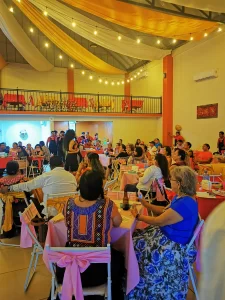 Invitados disfrutando de una fiesta en un salón decorado con telas y luces cálidas