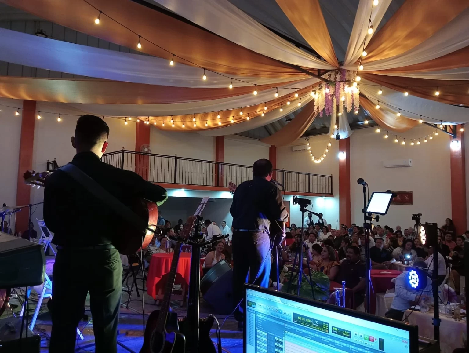 Músicos y cantantes actuando en un evento en el salón Arboledas