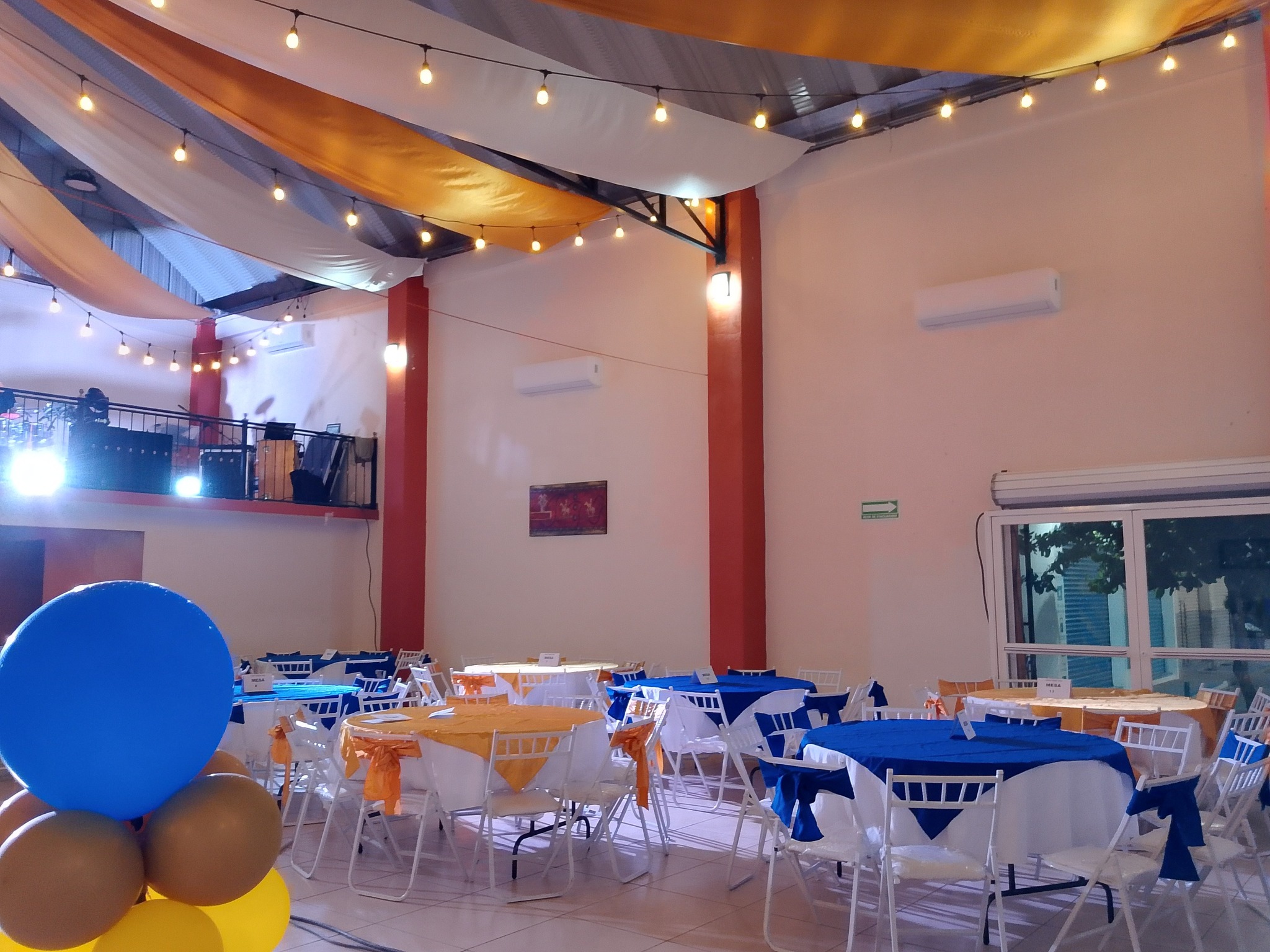 espacio de mesas y sillas adornado para un salón de eventos