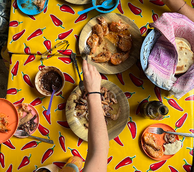 Comida istmeña en mesa familiar de La Cocina de Grecia, con camarones, tortillas hechas a mano, frijoles y platillos típicos de Magdalena Tlacotepec, Oaxaca.