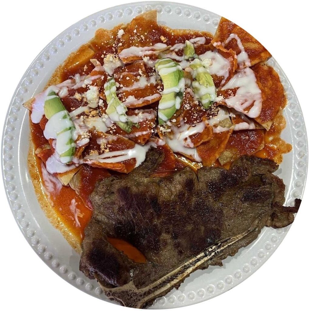 Plato de chilaquiles rojos con carne asada estilo istmeño, servido con crema, queso rallado y rebanadas de aguacate, típico de la cocina oaxaqueña en Unión Hidalgo.