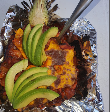 Piña rellena estilo istmeño con queso fundido, carne y rebanadas de aguacate, servida en hoja de plátano en La Cocina de Grecia, Magdalena Tlacotepec, Oaxaca.