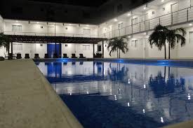 Vista nocturna de la alberca del Hotel Santa Cruz Juchitán, un lugar ideal para relajarse tras una celebración en el Salón Arboledas