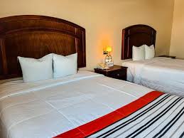 Habitación con dos camas matrimoniales en el Hotel Juchitán Inn, ideal para descansar después de un evento en el Salón Arboledas Juchitán