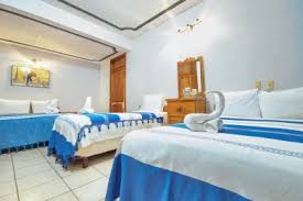 Habitación con camas matrimoniales decoradas con toallas en forma de cisne y tonos azules en el Hotel Central de Juchitán