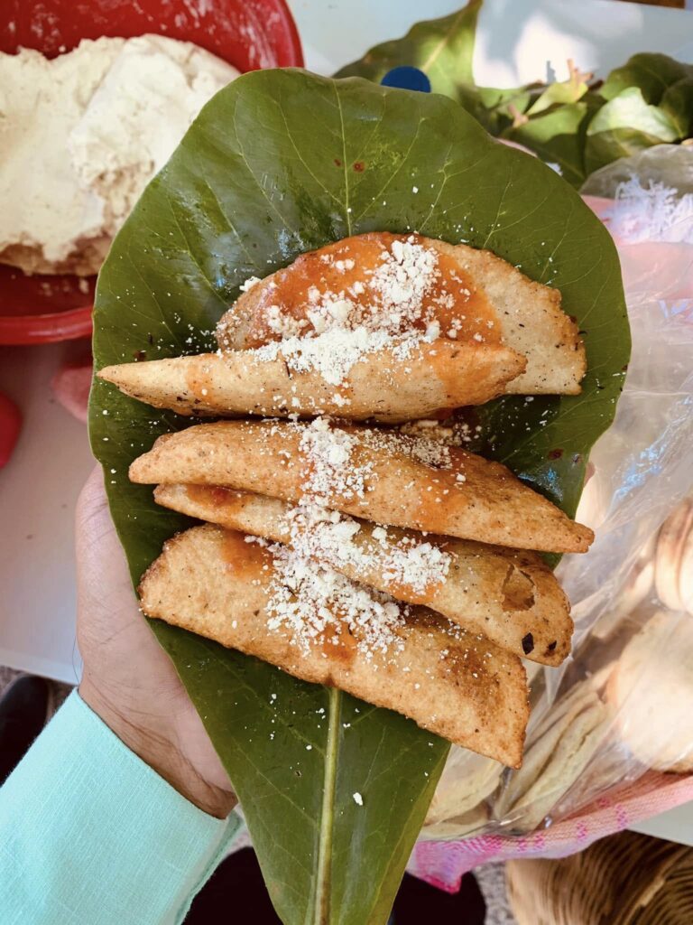 Empanadas doradas servidas en hoja verde, comida típica de Tlacotepec, Oaxaca