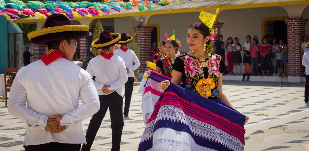 Parejas bailando con trajes típicos del Istmo de Tehuantepec durante una celebración en Oaxaca