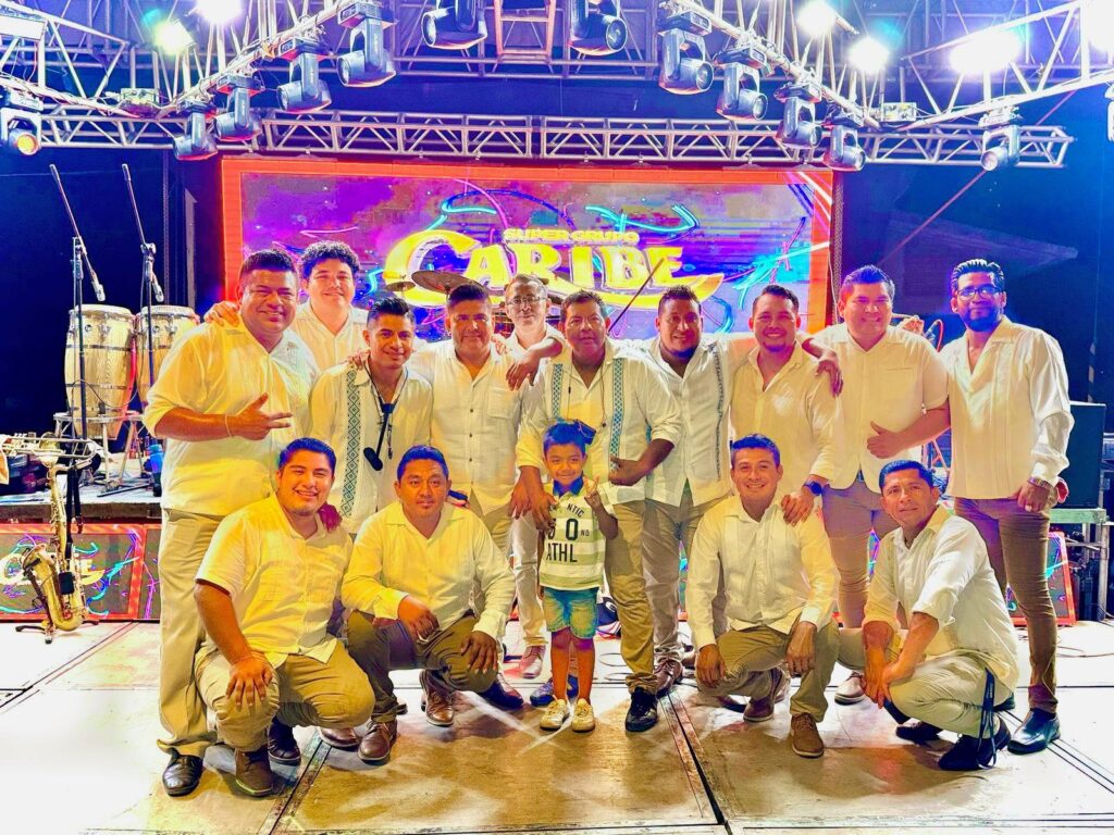 Integrantes del grupo Caribe posando en el escenario al finalizar su presentación