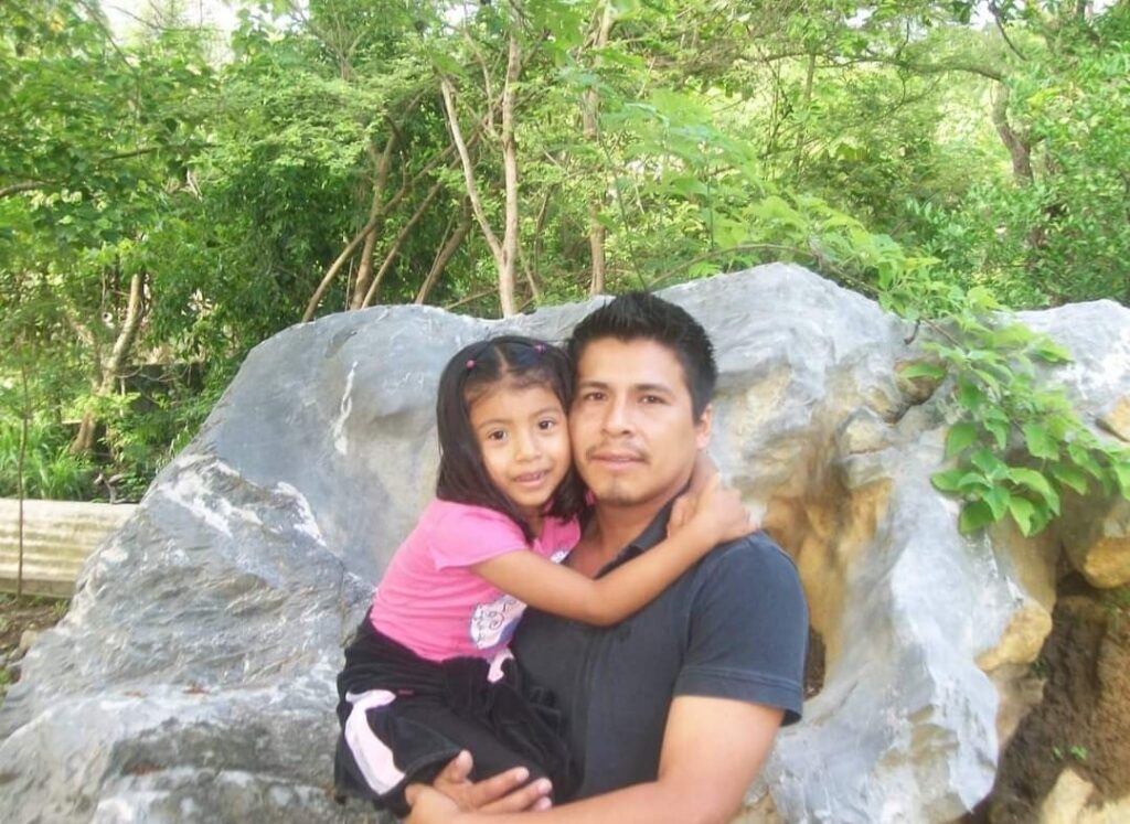 Padre abrazando a su hija en un entorno natural