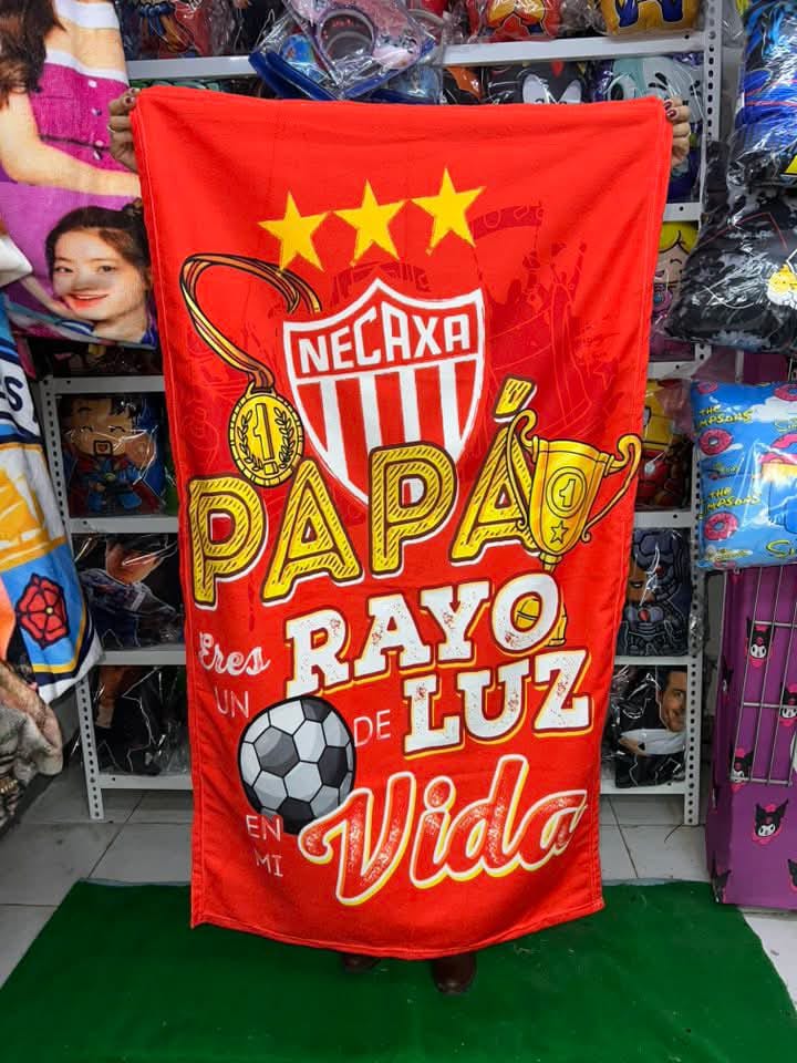 Cobija del Club Necaxa en color rojo con la frase “Papá, eres un rayo de luz en mi vida” con detalles de balón.