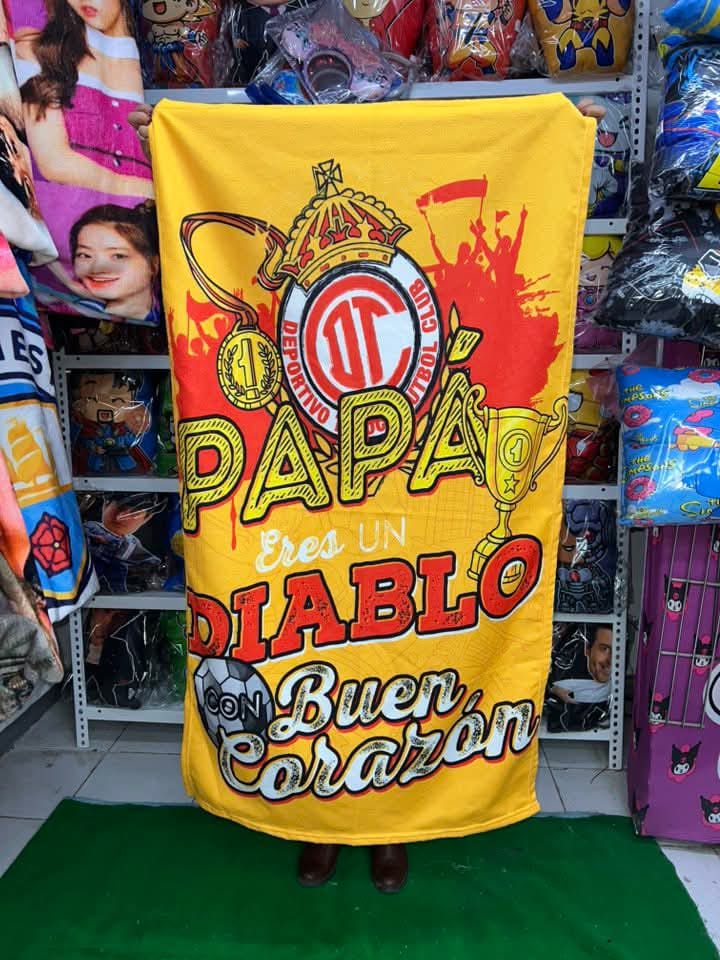 Cobija roja con temática del Deportivo Toluca, con la frase “Papá, eres un diablo con buen corazón”.