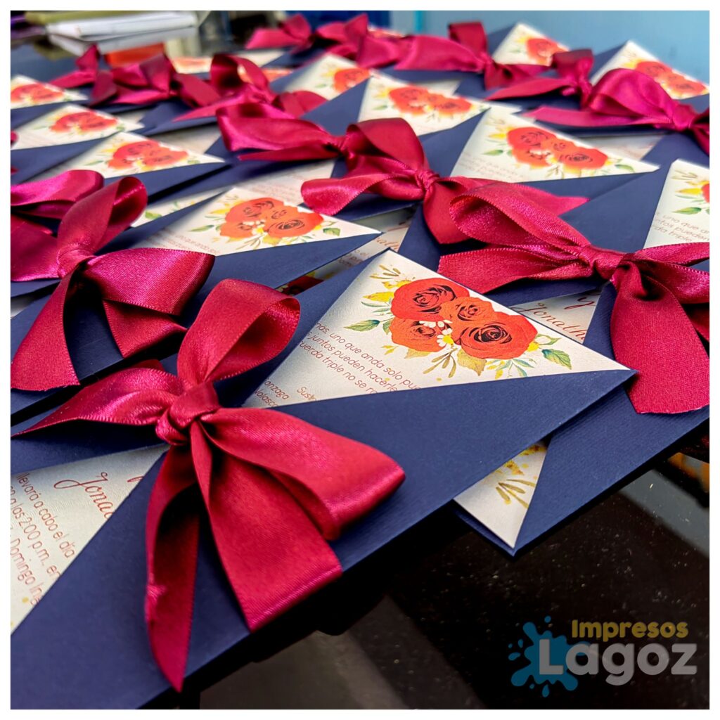 Invitaciones de boda personalizadas con diseño floral y moños rojos, hechas por Impresos Lagoz en Oaxaca
