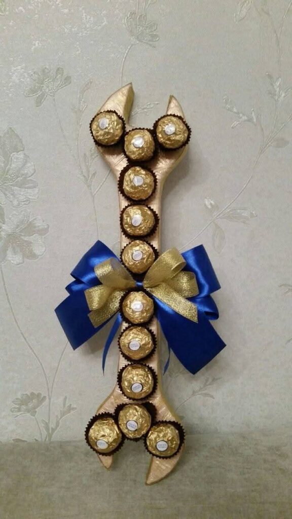 Llave inglesa decorativa cubierta con chocolates Ferrero Rocher y un moño azul y dorado para regalar en el Día del Padre.