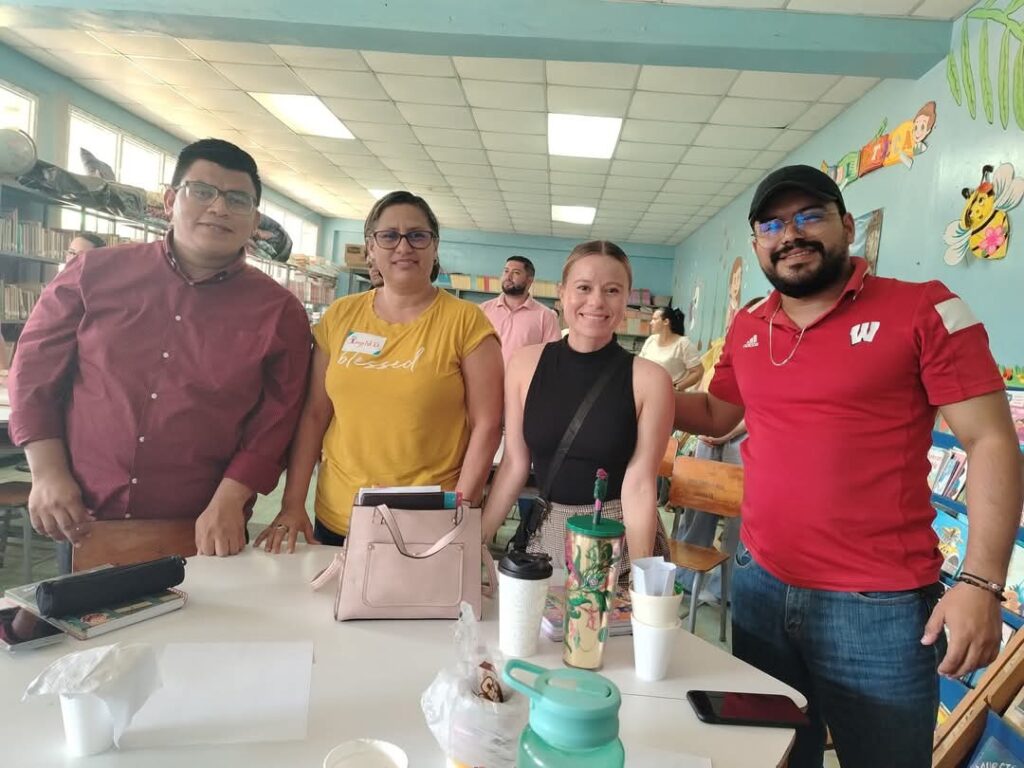 Grupo de docentes reunidos en un salón decorado con temática infantil durante una actividad educativa.