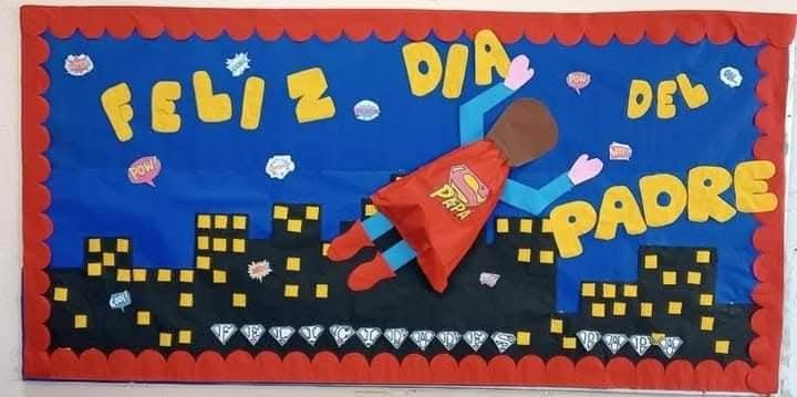 Mural creativo con un superhéroe de espaldas volando sobre una ciudad, con la frase “Feliz Día del Padre”.
