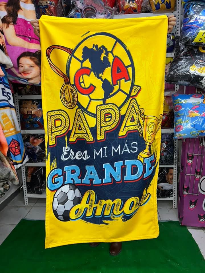 Cobija amarilla del Club América con la frase "Papá, eres mi más grande amor", decorada con balón y trofeo.
